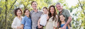 multigenerational family outside smiling showing beautiful teeth and natural-looking restorations