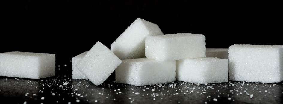 pile of sugar cubes on black background