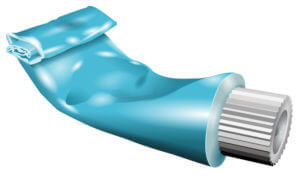 Partially squeezed collapsible blue tube of toothpaste with a white corrugated cap