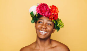 Woman smiles while wearing a floral crown of spring flowers