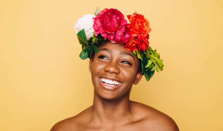 Woman smiles while wearing a floral crown of spring flowers