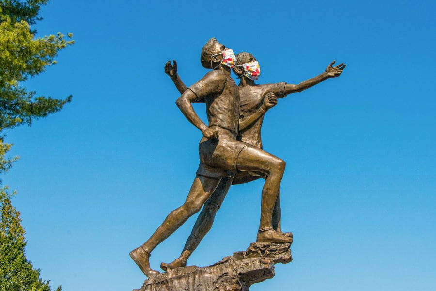 Photo of two bronze statues wearing face masks due to coronavirus