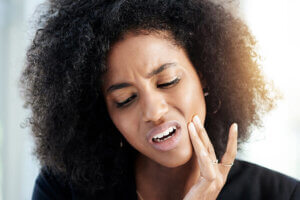 Attractive young black woman with a toothache