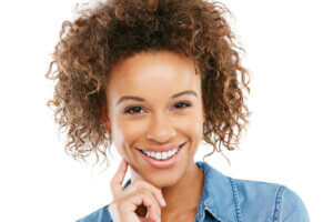 Cute smiling lady with dark curly hair and beautiful, straight teeth.