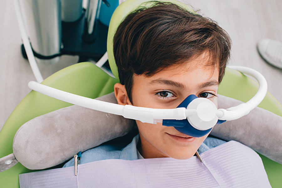 Boy in the dental chair with a mask for nitrous oxide dental sedation.